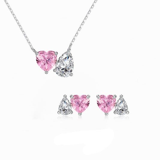 Jewelry set with pink and clear heart-shaped stones on a white background, branded 'Dike Jewelry'.