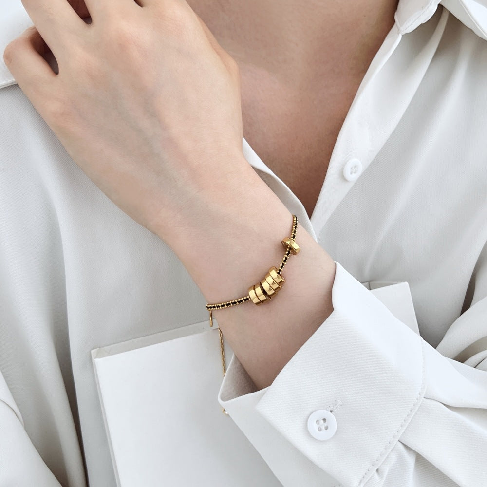 Noir Luxe Coin Charm Bracelet – 925 Sterling Silver with Black-Gold Braided Design.
