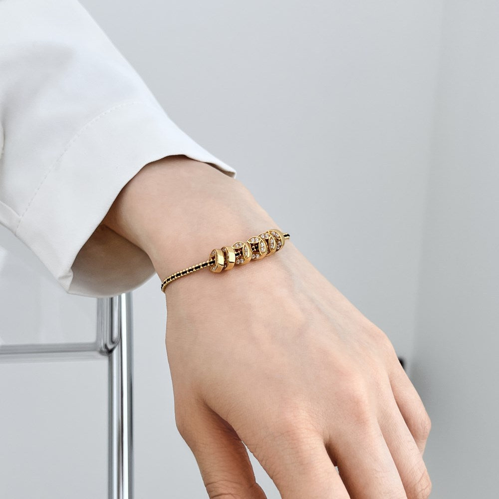 Noir Luxe Coin Charm Bracelet – 925 Sterling Silver with Black-Gold Braided Design.