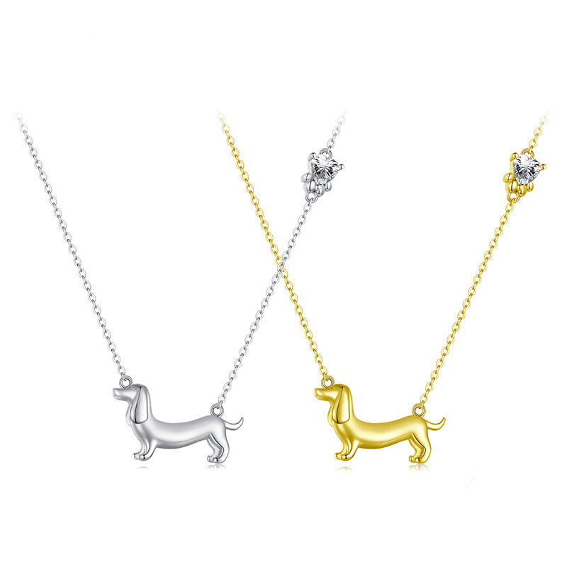 Two dog-shaped pendants, one in silver and one in gold, on white backgrounds.