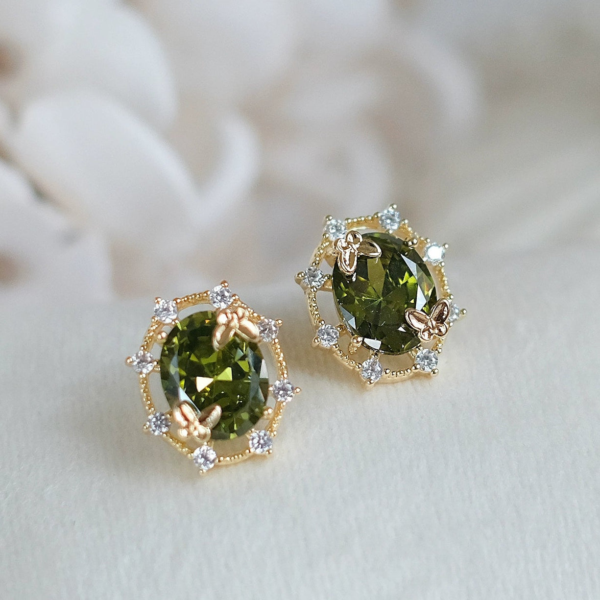 Green gemstone earrings with gold accents on a white background, branded 'SW accessories'.